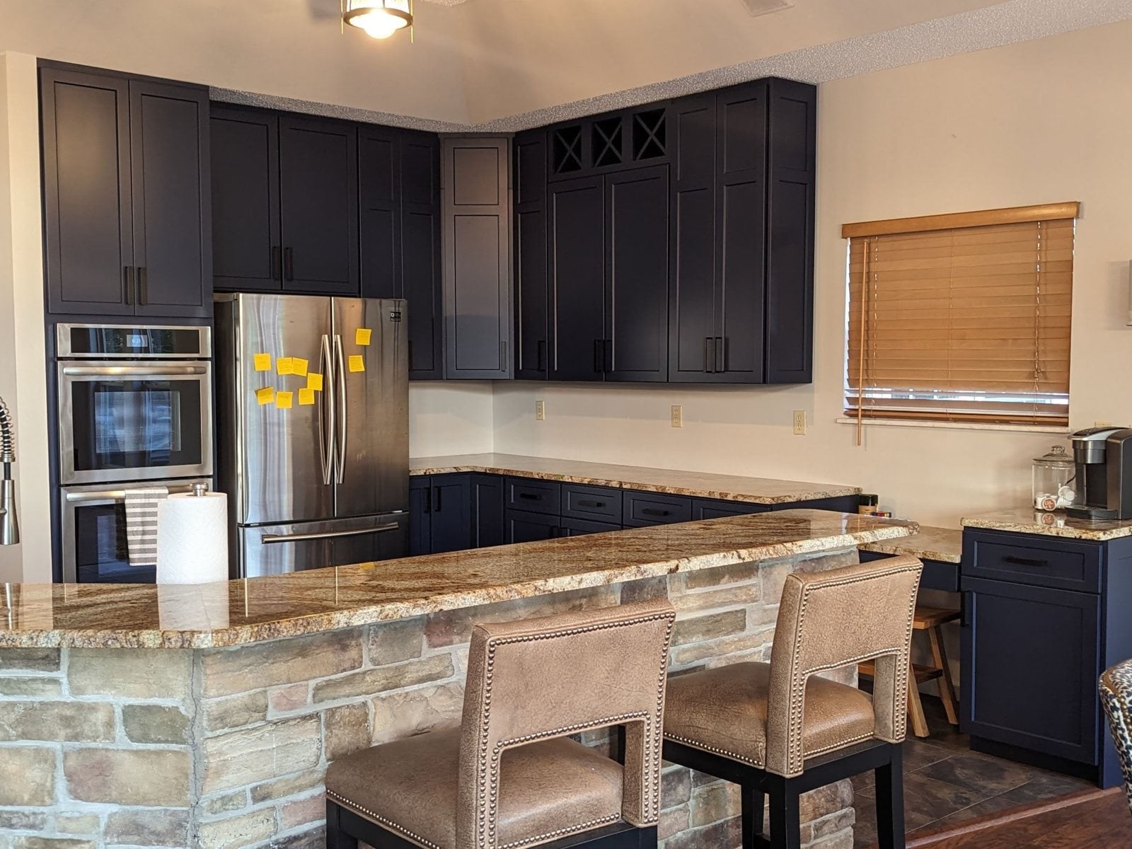 The same kitchen after, navy cabinets